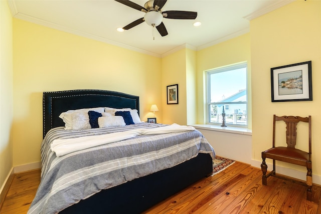 bedroom featuring hardwood / wood-style flooring, ceiling fan, and crown molding