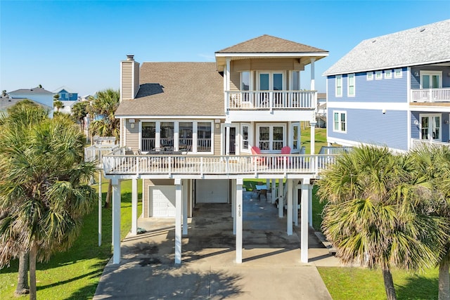 rear view of house featuring a garage, a balcony, and a carport