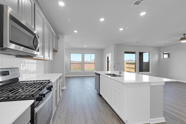 kitchen featuring tasteful backsplash, visible vents, open floor plan, appliances with stainless steel finishes, and a sink