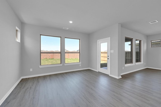 spare room with recessed lighting, visible vents, baseboards, and dark wood finished floors