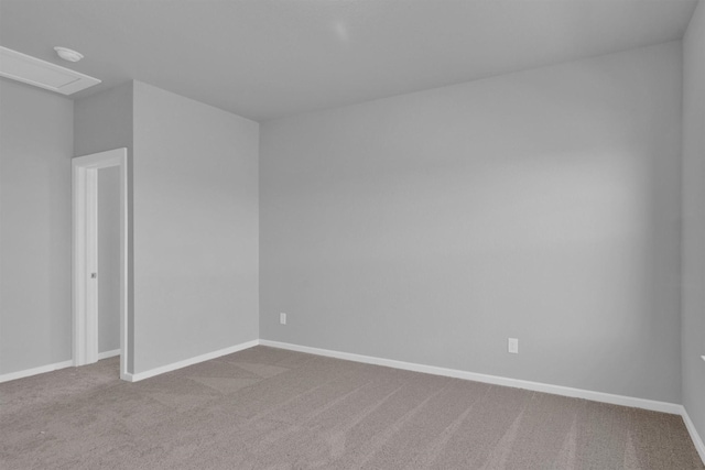 carpeted empty room featuring baseboards