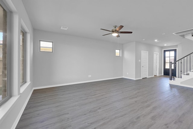 spare room featuring stairs, wood finished floors, visible vents, and baseboards