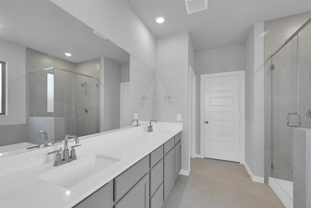 bathroom featuring visible vents, a shower stall, and a sink