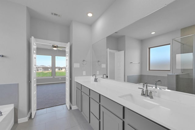 bathroom with visible vents, double vanity, a sink, a shower stall, and a garden tub