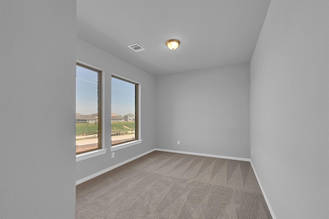 carpeted empty room with visible vents and baseboards