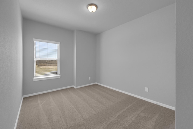 empty room featuring baseboards and carpet floors