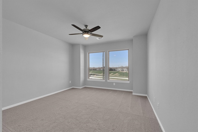 empty room with visible vents, baseboards, carpet floors, and ceiling fan