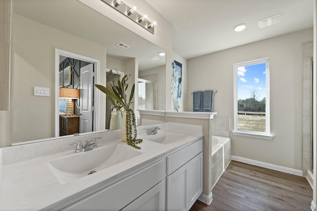 bathroom with independent shower and bath, wood-type flooring, and vanity