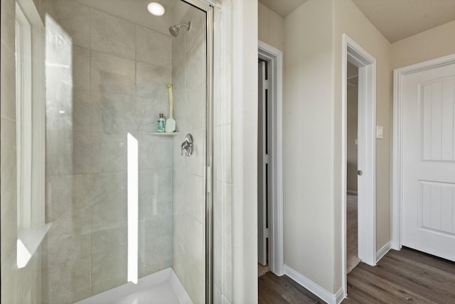 bathroom featuring a shower with door and hardwood / wood-style flooring