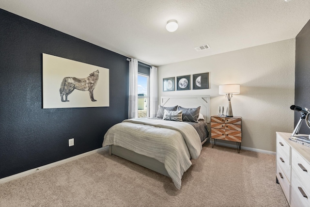 bedroom with light carpet and a textured ceiling