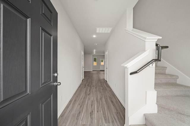 hall with recessed lighting, visible vents, stairway, wood finished floors, and baseboards