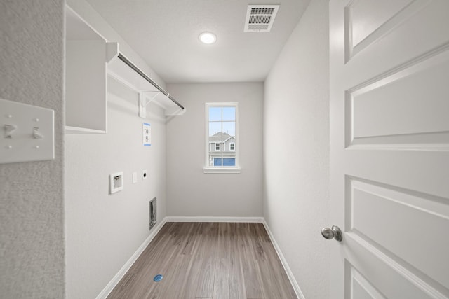 clothes washing area with laundry area, baseboards, visible vents, hookup for an electric dryer, and washer hookup