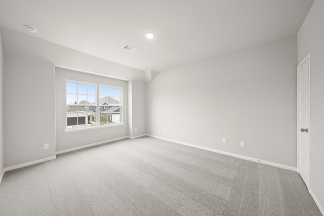 carpeted spare room featuring baseboards, visible vents, and recessed lighting