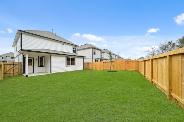 back of house featuring a yard, a patio, a fenced backyard, and a residential view