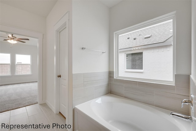 bathroom featuring ceiling fan and a tub to relax in