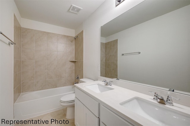 full bathroom with tile patterned floors, toilet, tiled shower / bath combo, and vanity