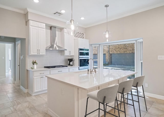 kitchen with visible vents, stainless steel double oven, ornamental molding, light countertops, and wall chimney exhaust hood