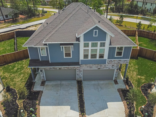 view of front of property featuring a garage, concrete driveway, stone siding, roof with shingles, and a front lawn