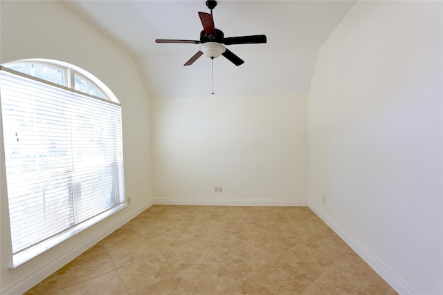 spare room featuring lofted ceiling, ceiling fan, and baseboards