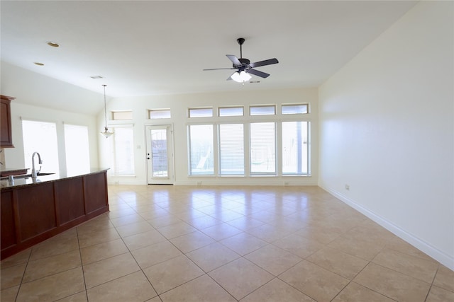 unfurnished living room with plenty of natural light, a sink, lofted ceiling, and ceiling fan