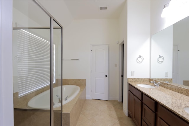 full bath featuring double vanity, visible vents, a garden tub, tile patterned flooring, and a sink