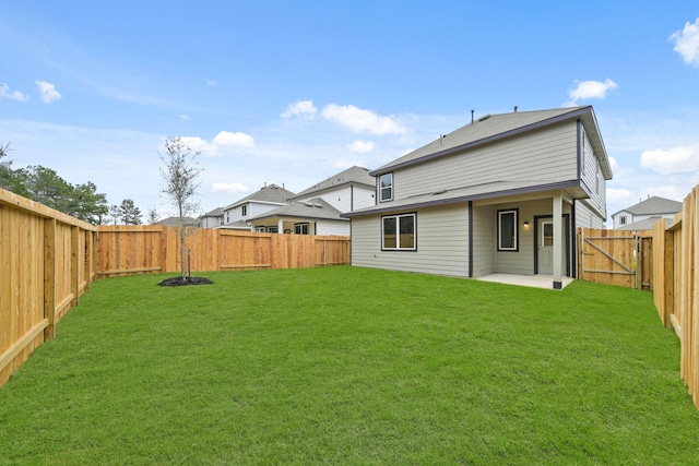 back of property with a patio area, a fenced backyard, a lawn, and a gate