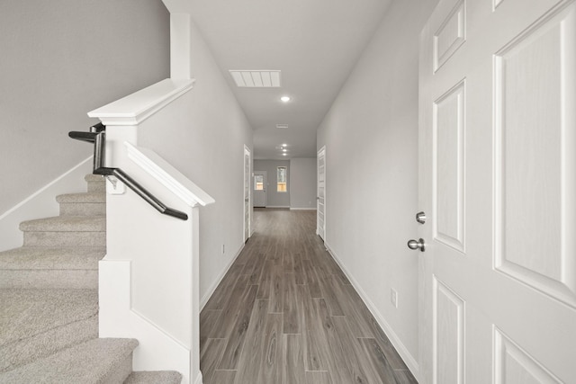 corridor with baseboards, visible vents, wood finished floors, and recessed lighting