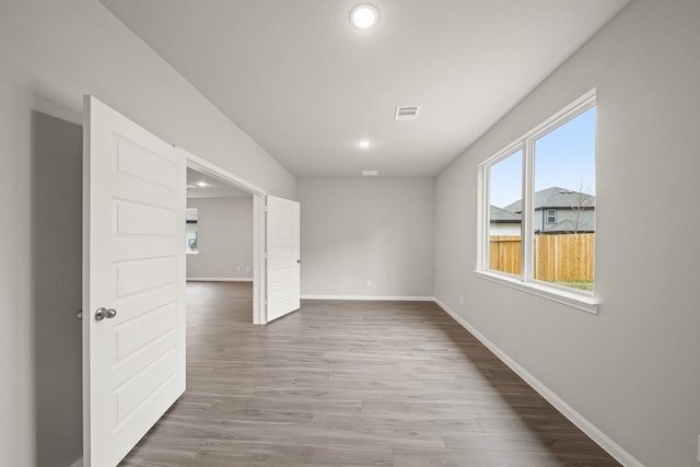 spare room with visible vents, baseboards, wood finished floors, and recessed lighting