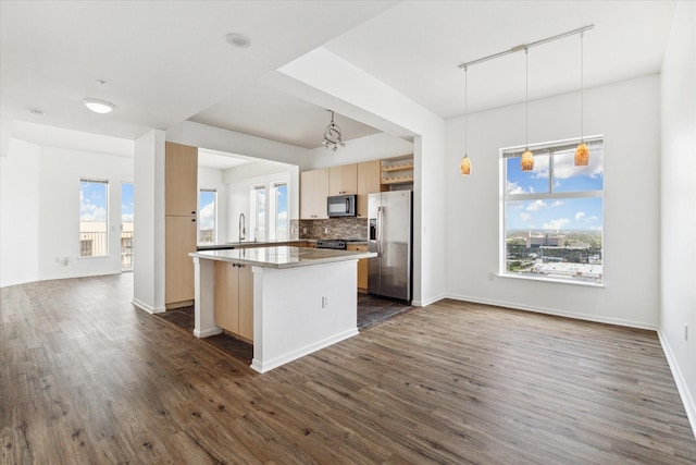 kitchen with sink, decorative light fixtures, light brown cabinets, stainless steel fridge, and backsplash