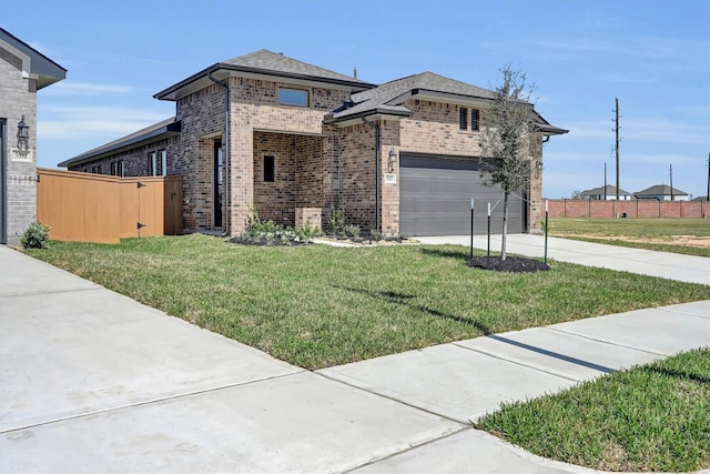 view of front facade featuring brick siding, a front lawn, fence, a garage, and driveway