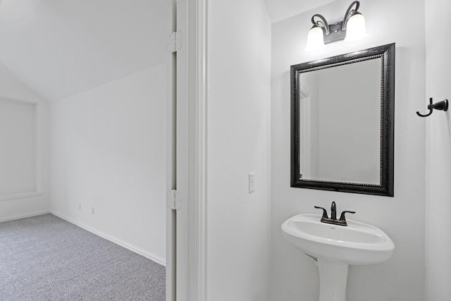 bathroom featuring vaulted ceiling and sink