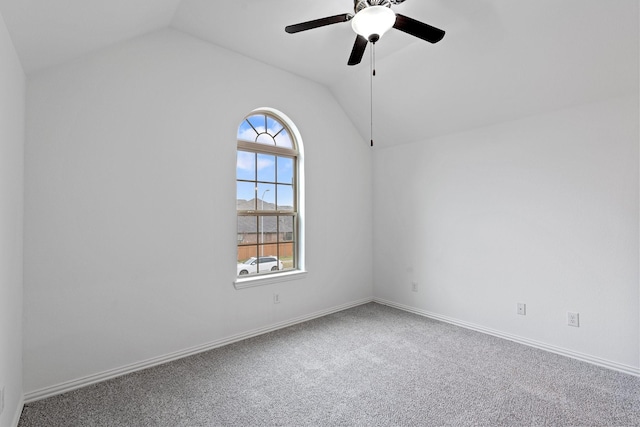 empty room featuring lofted ceiling, ceiling fan, and carpet flooring