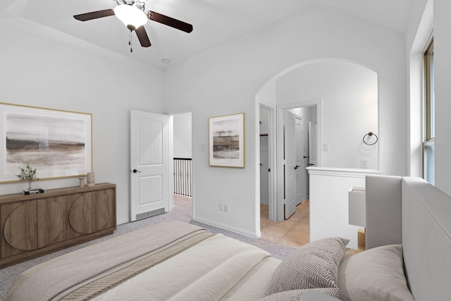 bedroom with ceiling fan, a walk in closet, and light colored carpet