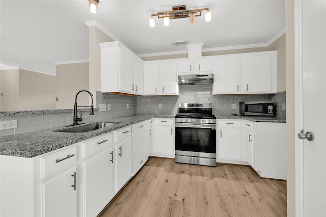 kitchen with dark stone countertops, appliances with stainless steel finishes, sink, and white cabinets