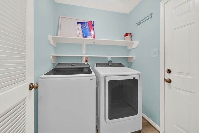 laundry area with hardwood / wood-style flooring and separate washer and dryer