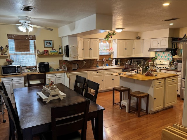 interior space with stainless steel microwave, white cabinetry, and visible vents