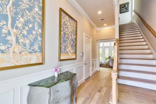 interior space with light hardwood / wood-style flooring and ornamental molding