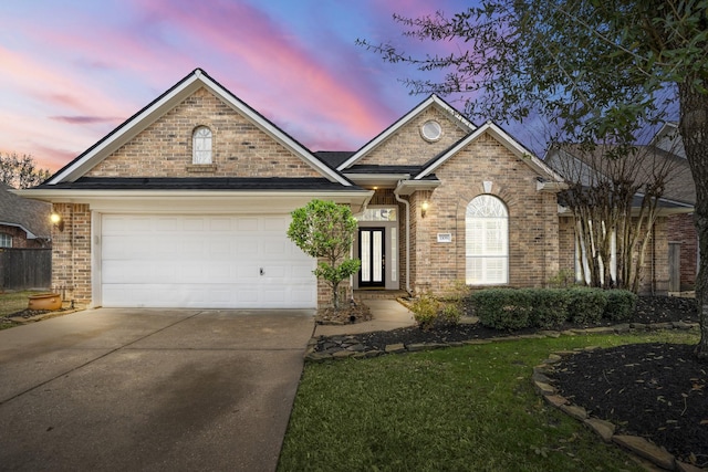 view of front of house with a garage, concrete driveway, and brick siding