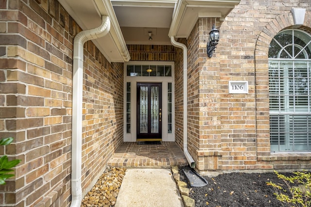 entrance to property featuring french doors and brick siding