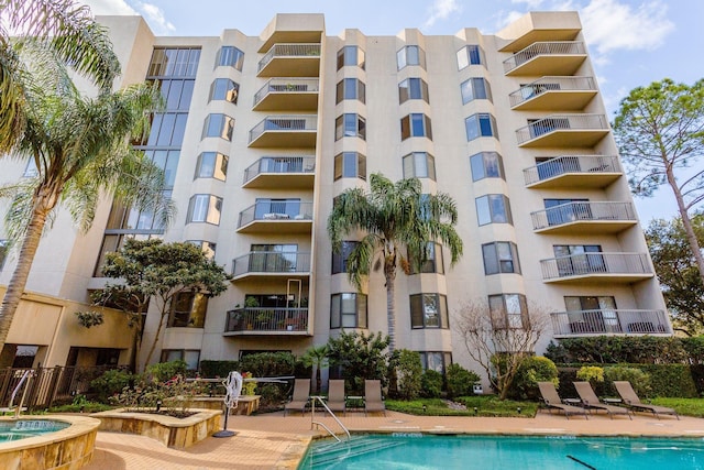 view of building exterior with a patio and a community pool