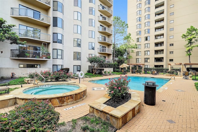 view of pool with a hot tub and a patio