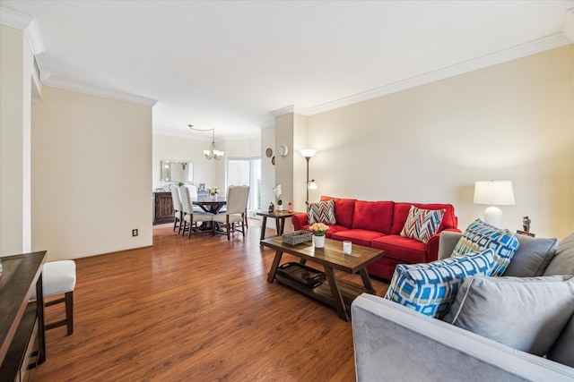 living room with crown molding, wood-type flooring, and a chandelier