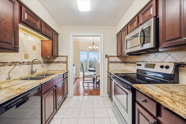 kitchen with light stone counters, appliances with stainless steel finishes, light tile patterned flooring, and sink