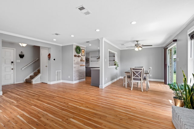 unfurnished dining area with light hardwood / wood-style flooring, ornamental molding, and ceiling fan