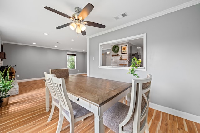 dining space featuring crown molding, light hardwood / wood-style flooring, and ceiling fan