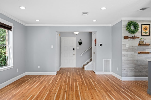 foyer featuring ornamental molding and light wood-type flooring