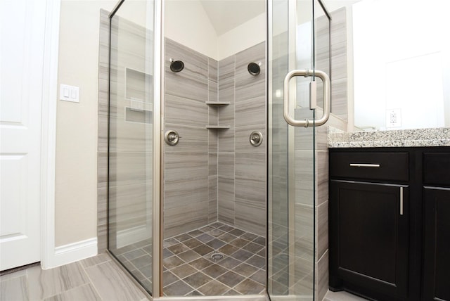 bathroom featuring vanity and a shower with door