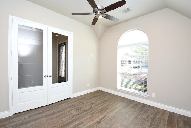 empty room with dark wood-type flooring, ceiling fan, vaulted ceiling, and french doors