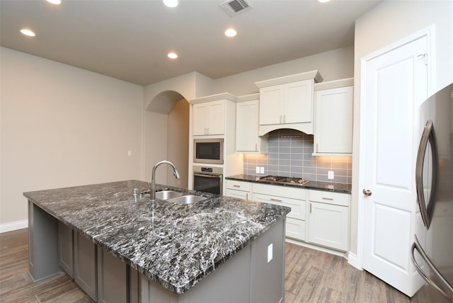 kitchen with white cabinetry, appliances with stainless steel finishes, a large island, and sink