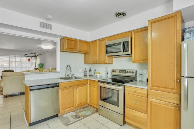 kitchen with light tile patterned flooring, sink, decorative backsplash, kitchen peninsula, and stainless steel appliances